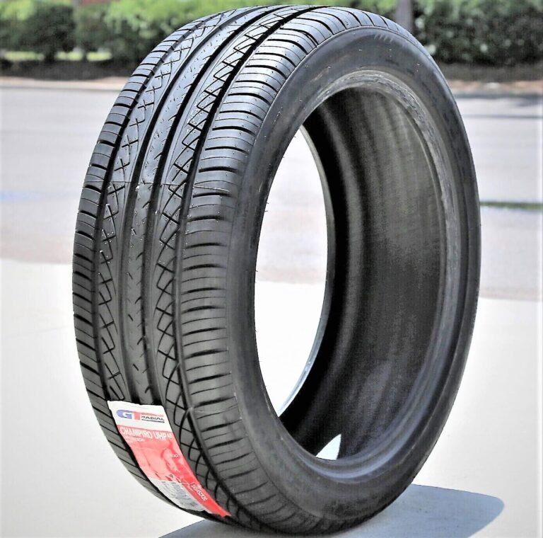 A new black tire with tread and a red label stands upright