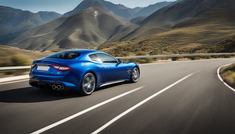 Blue sports car driving on a winding road with mountain backdrop